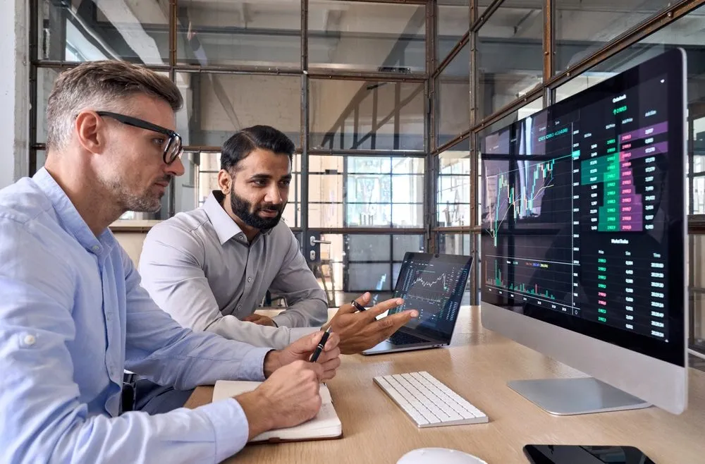 two businessmen work at computer
